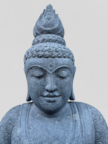 Stone statue of a Buddha head on a plain background