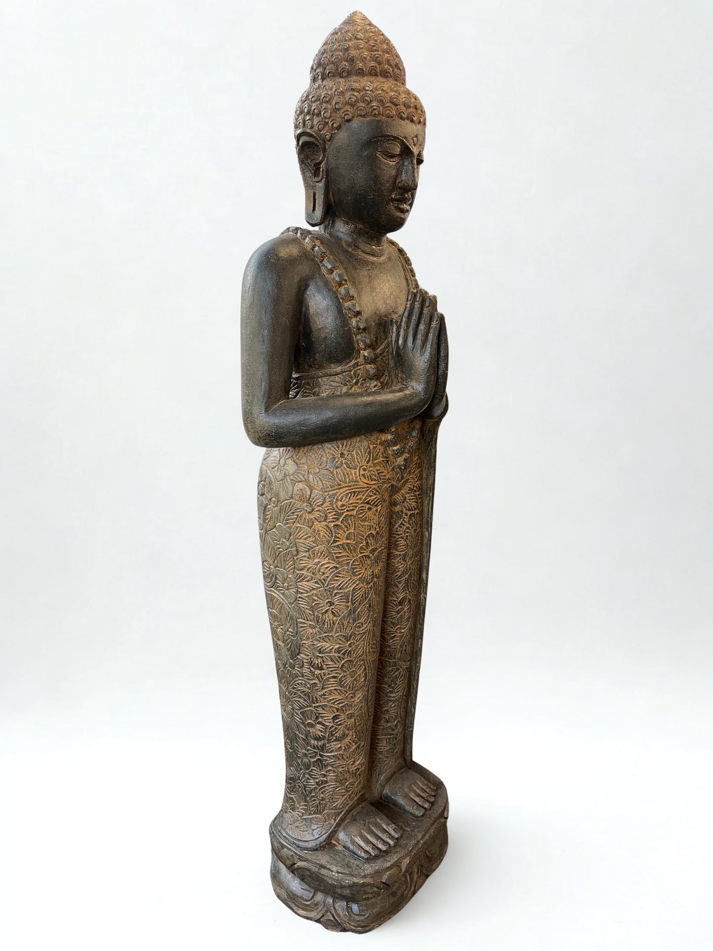 Bronze statue of a standing Buddha on a white background