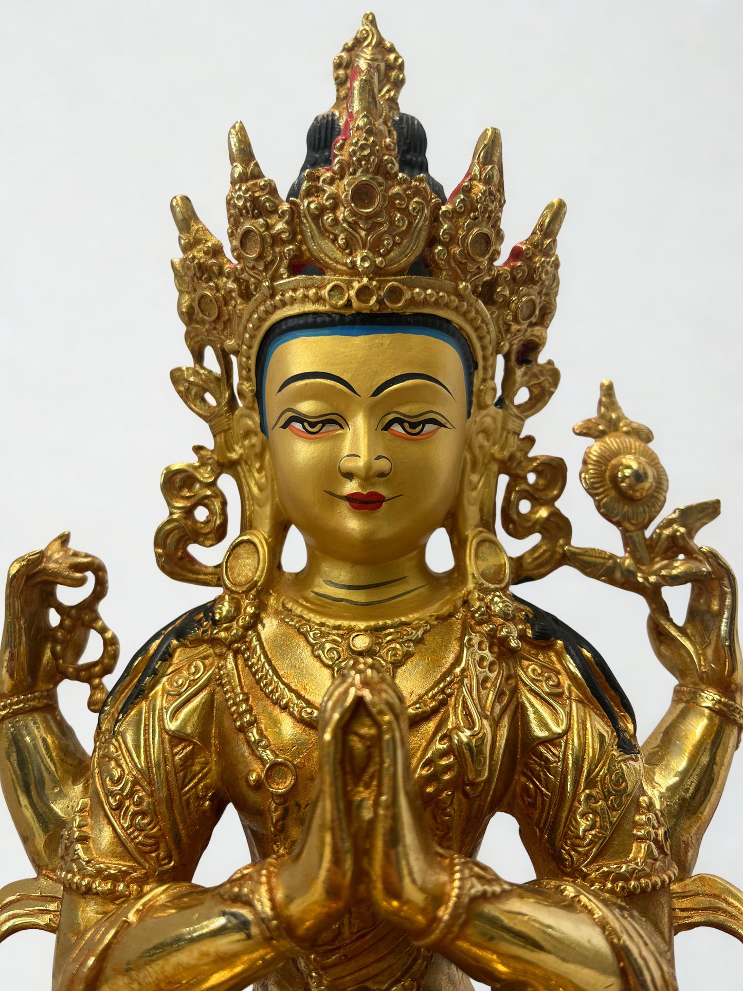 Gold-colored Chenrezig statue with intricate designs on a white background, Tibetan Chenrezig statue, brass Avalokiteshvara sculpture, Buddhist compassion deity, Himalayan art statue, meditation altar décor, spiritual home decoration