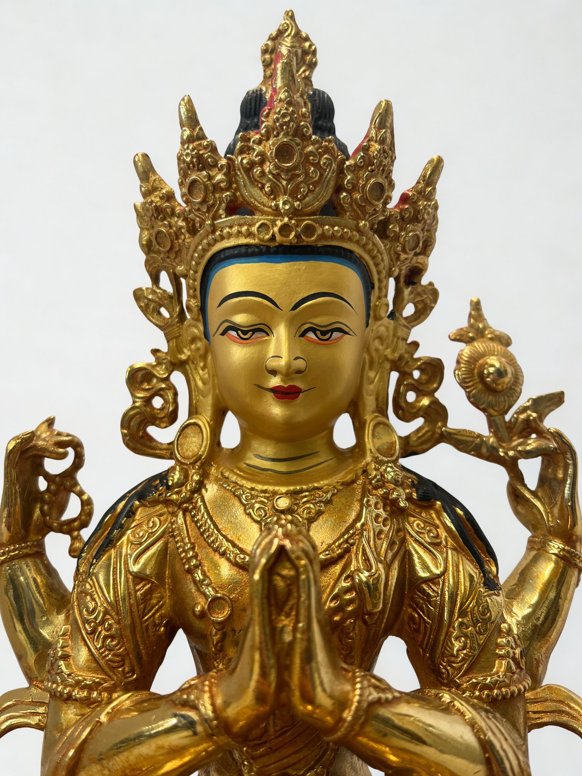 Gold-colored Chenrezig statue with intricate designs on a white background, Tibetan Chenrezig statue, brass Avalokiteshvara sculpture, Buddhist compassion deity, Himalayan art statue, meditation altar décor, spiritual home decoration
