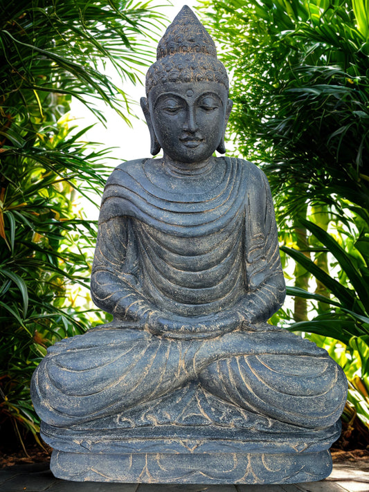 Stone Buddha statue in a garden setting with greenery