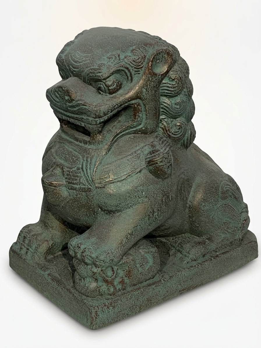A green patina stone or cast-iron Chinese guardian lion statue, shown from a three-quarter angle on a white background.