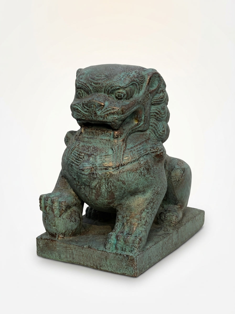 A traditional Chinese bronze-finished stone lion statue with a verdigris patina, sitting on a rectangular base against a plain white background.