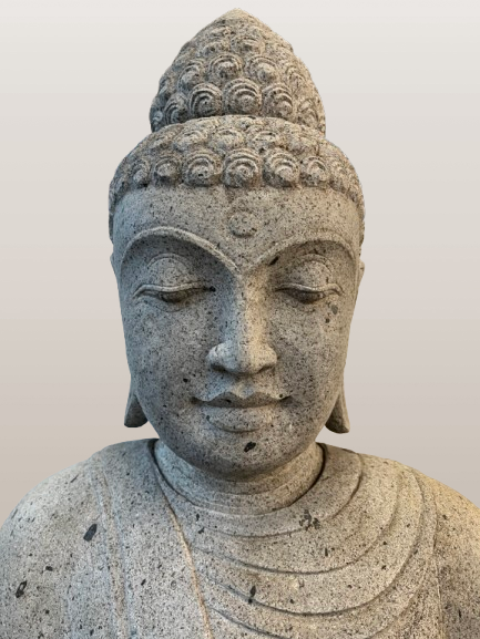 Stone statue of a Buddha figure against a plain background