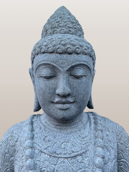 Stone statue of a Buddha figure against a plain background