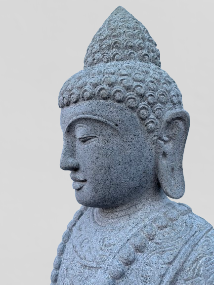 Stone statue of a Buddha head on a plain background