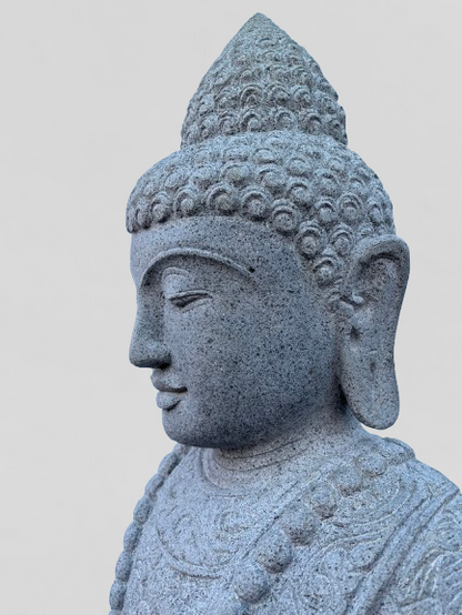 Stone statue of a Buddha head on a plain background