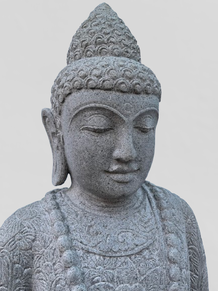 Stone statue of a Buddha with intricate details on a light gray background