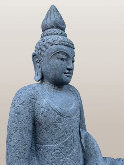 Stone statue of a seated figure with intricate patterns on a beige background