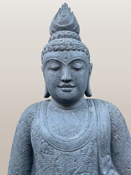 Stone statue of a seated Buddha with intricate details on a beige background