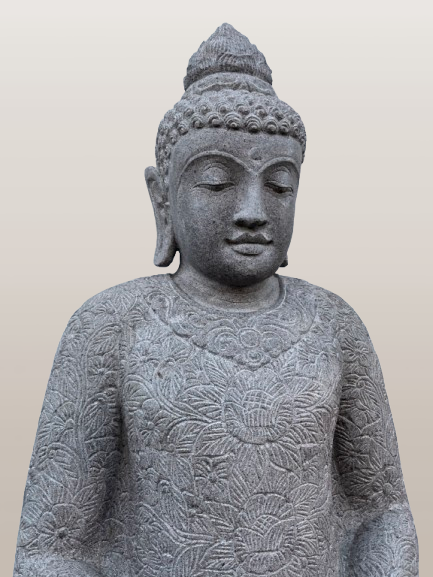 Stone statue of a seated Buddha with intricate carvings on a plain background