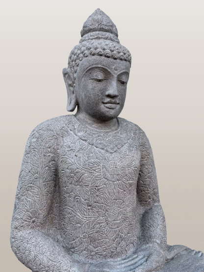 Stone statue of a seated Buddha on a plain background