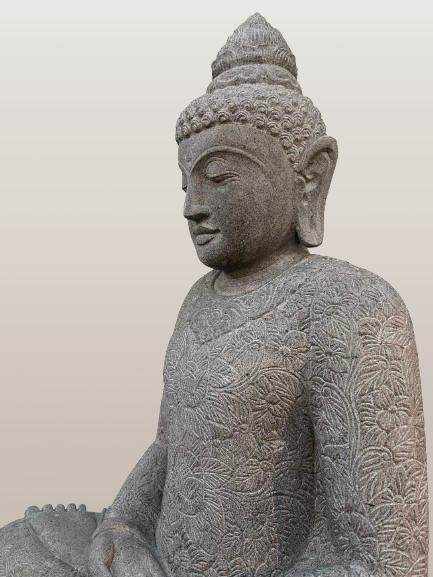 Stone statue of a seated Buddha with intricate patterns on a plain background