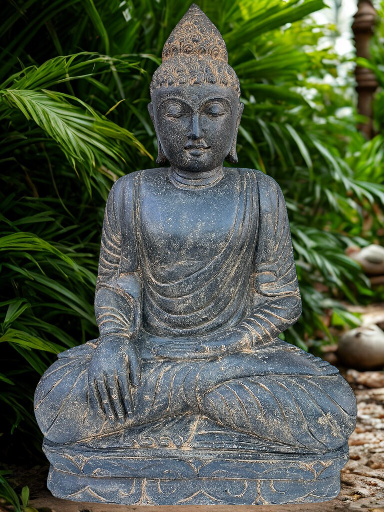 Stone Buddha statue in a garden setting with greenery