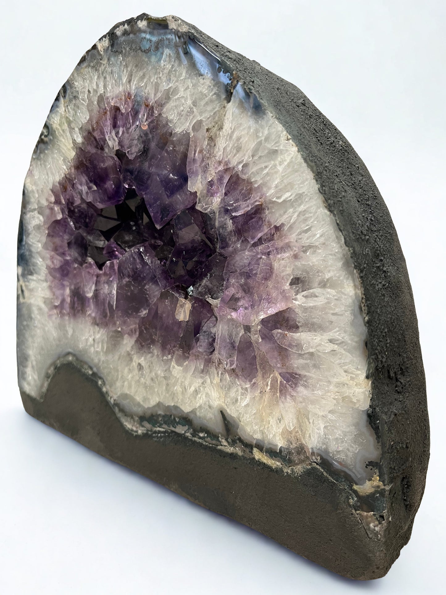 Amethyst geode with purple crystal center on a white background