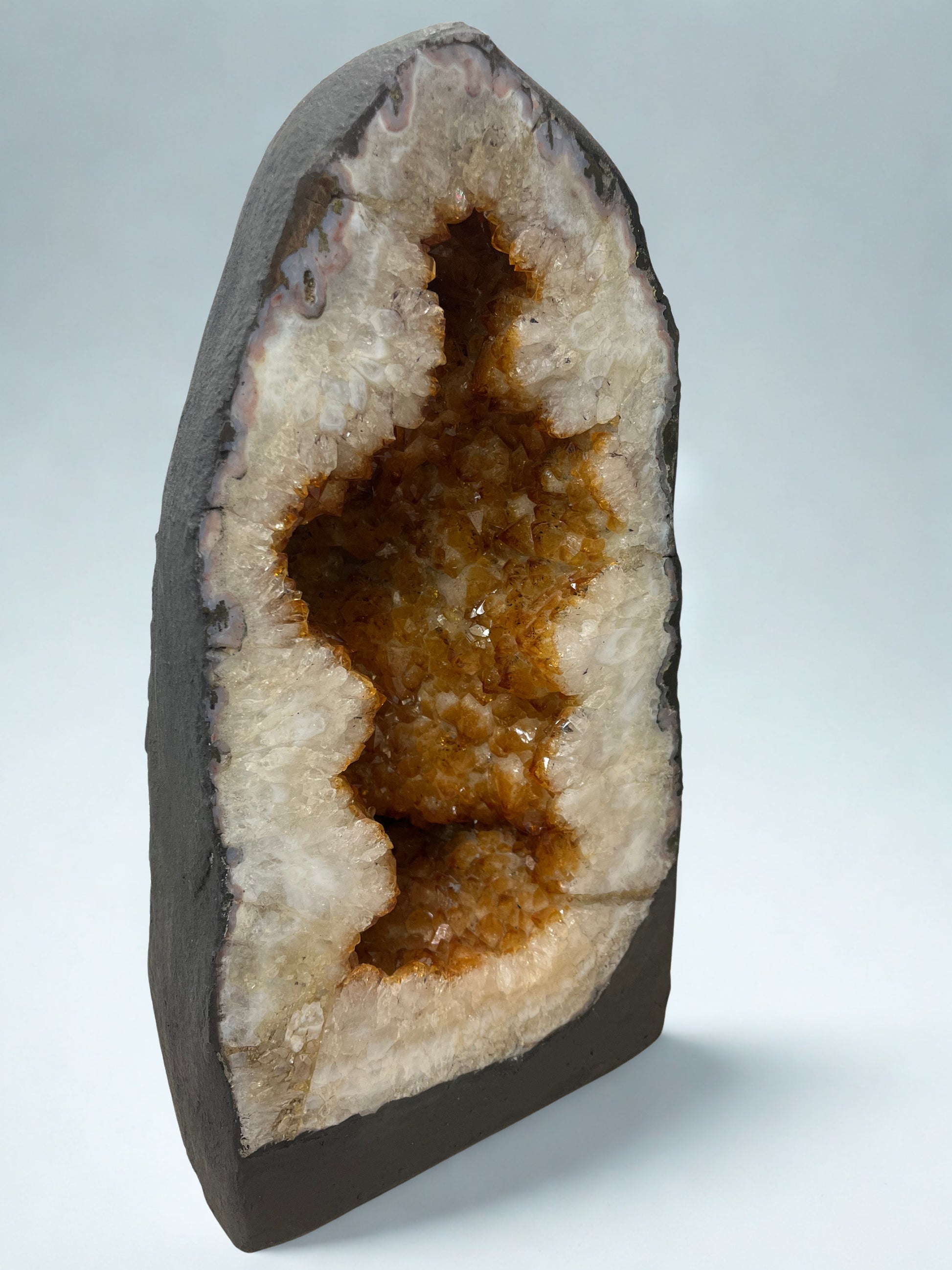 Citrine Geode with brown interior on a light gray background