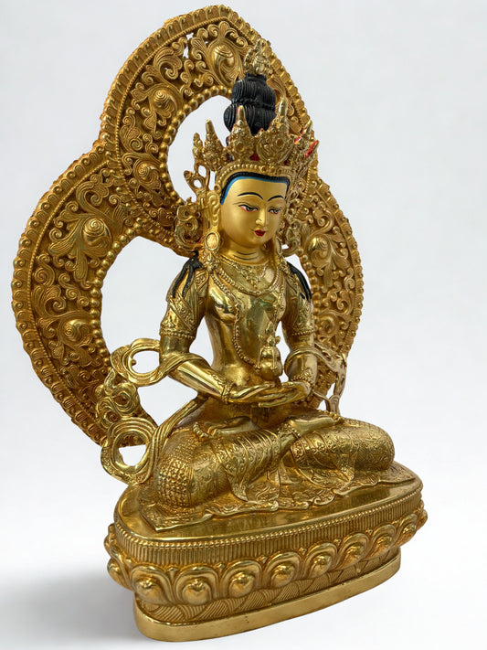 Gold-colored Amiayus Buddha statue with intricate designs on a white background